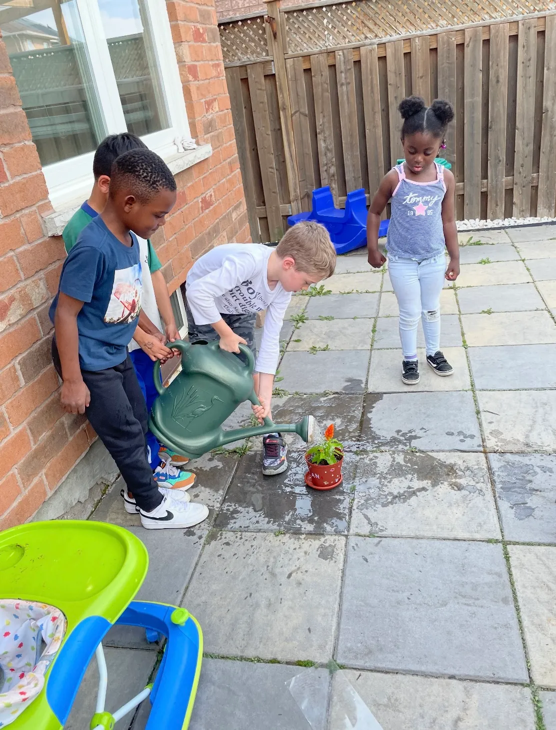 Photo of daycare kids watering plants